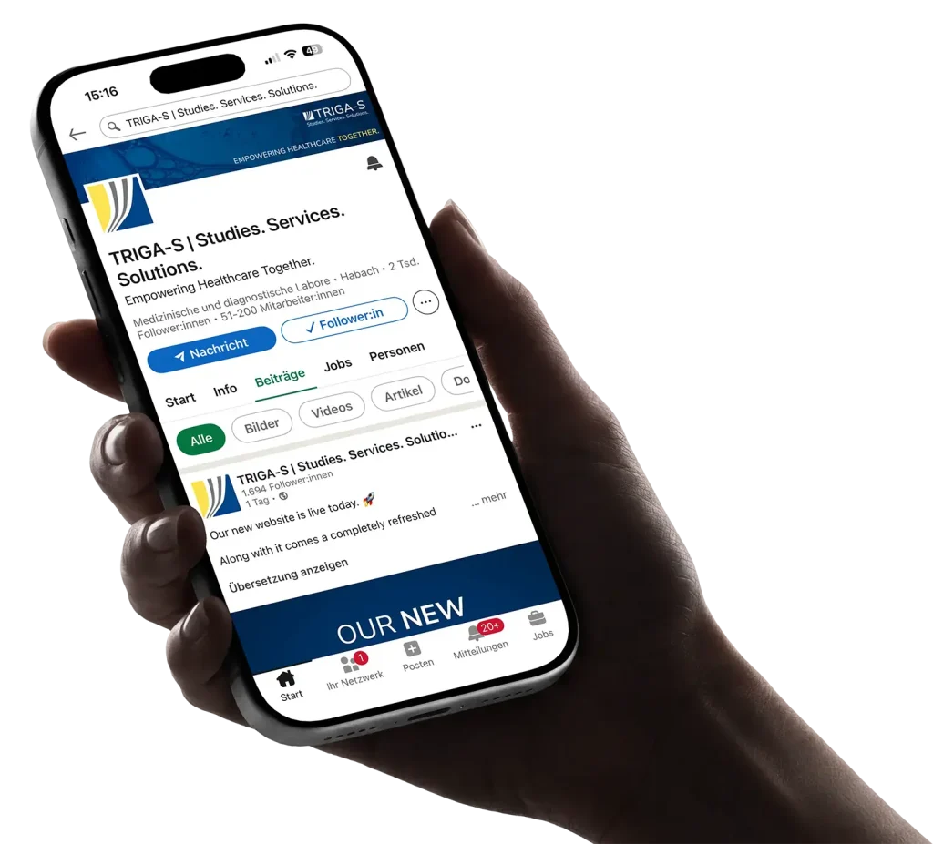 Eine Hand hält ein Smartphone, auf dem das LinkedIn-Profil von TRIGA-S | Studies. Services. Solutions. angezeigt wird. Auf dem Bildschirm sind das Profilbanner, Schaltflächen und ein Teil der Unternehmensbeschreibung zu sehen.