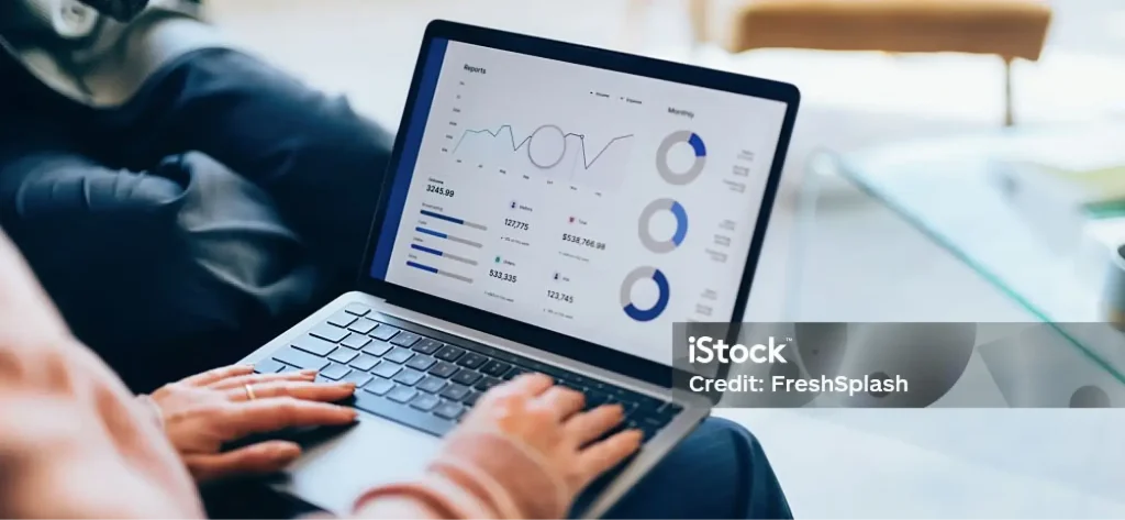Eine Person nutzt in einem modernen Büro oder an ihrem Arbeitsplatz zu Hause einen Laptop, auf dem Diagramme, Grafiken und Datenanalysen aus einem LIMS-Laborinformationsmanagementsystem angezeigt werden.